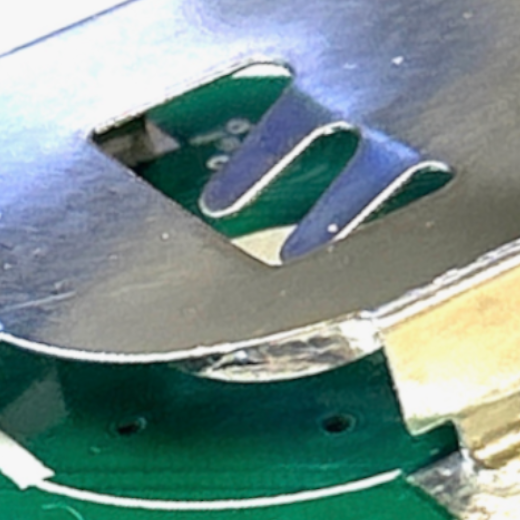 Close-up of the two metal prongs on the battery holder lid being pressed down